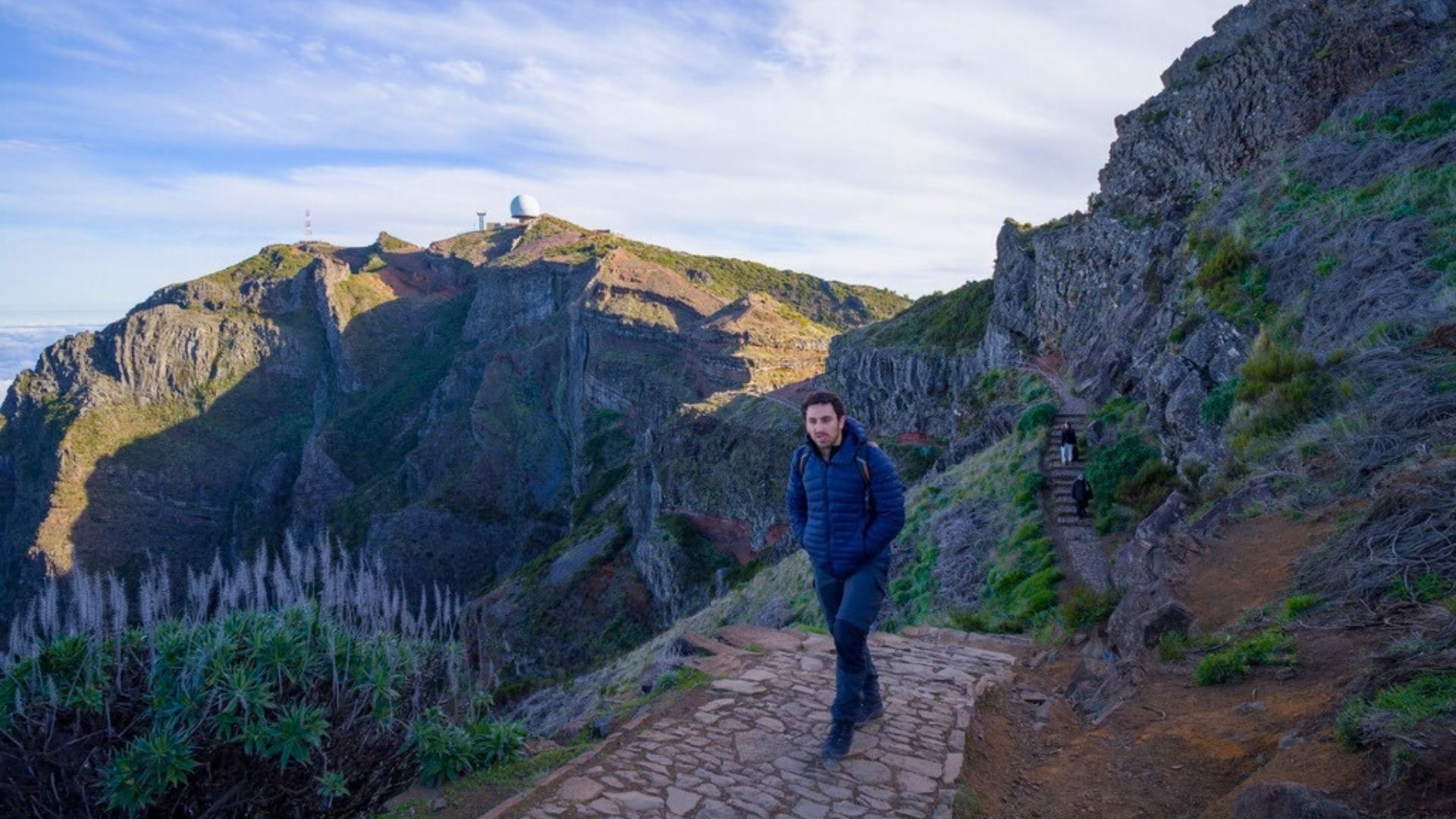 Solo hiker on PR1 trail from Pico Arieiro in Madeira on exposed mountain ridge